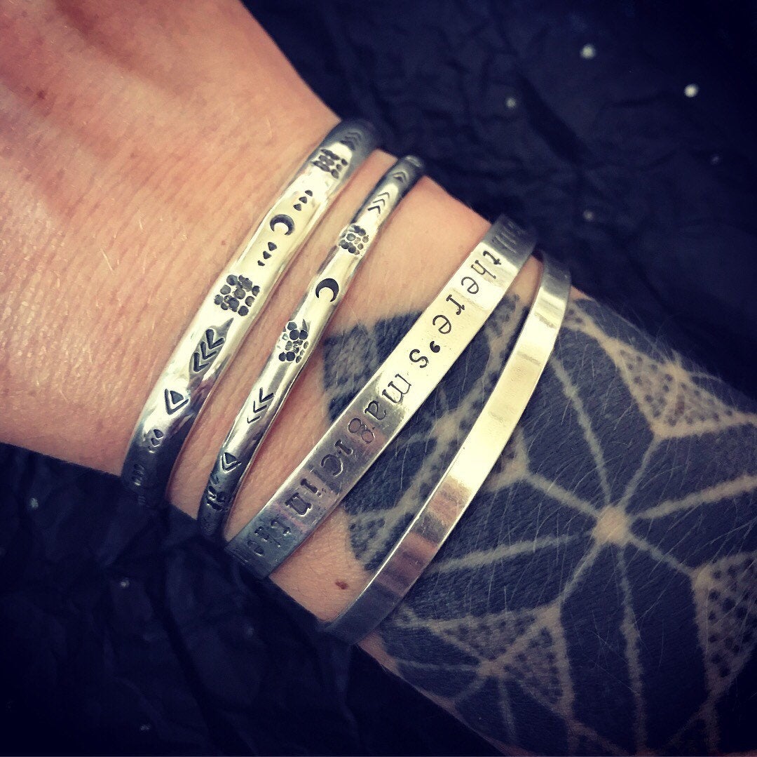 Image of 'Luna' symbol stamped cuff bracelet. Slim silver Aztec patterned cuff bracelet. 