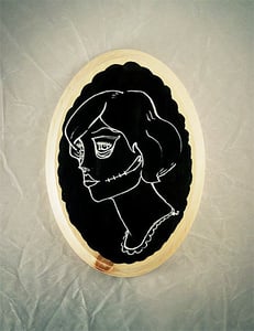 Image of Gypsy Skull Tattoo - white and black on a scalloped plaque