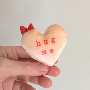 Image of Conversation Heart Pillow in Orange with HUG ME