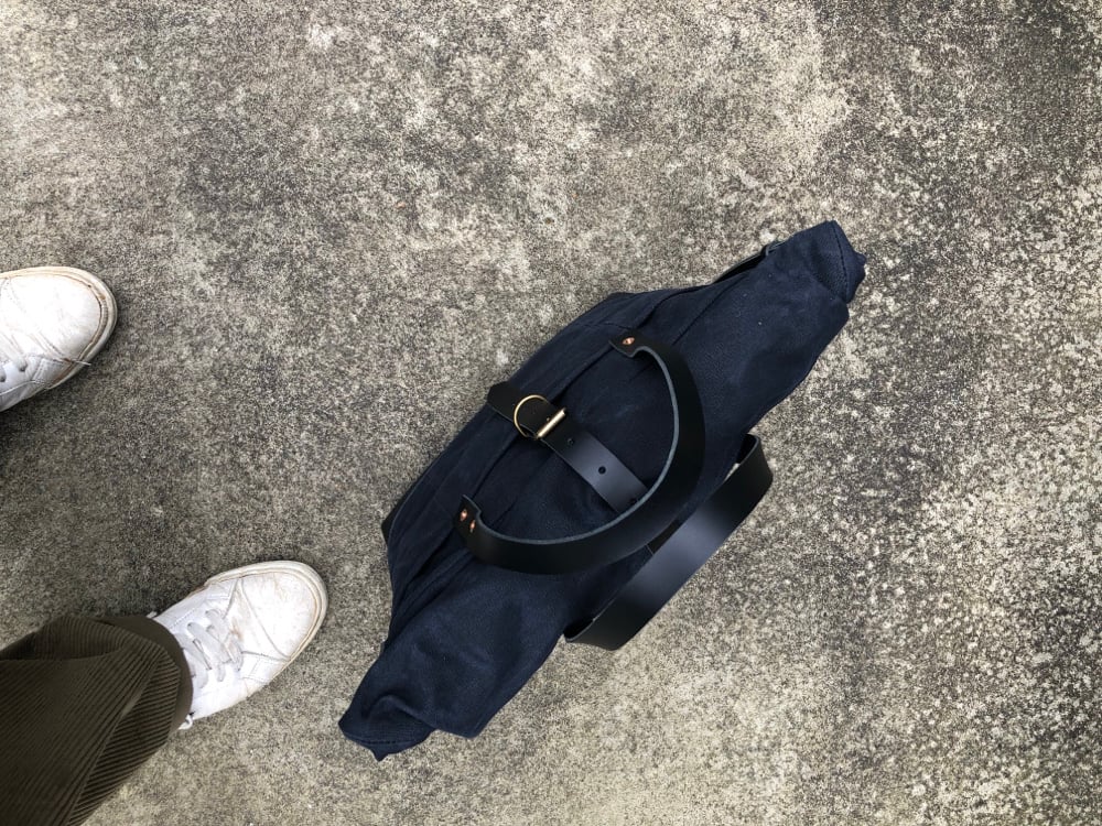 Image of Black waxed canvas carryall with luggage handle attachment leather handles and shoul