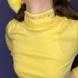 Yellow turtleneck with embroidered flower details