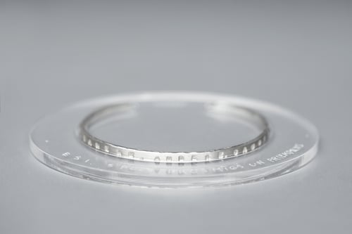 Image of thin silver bracelet with inscription in Latin