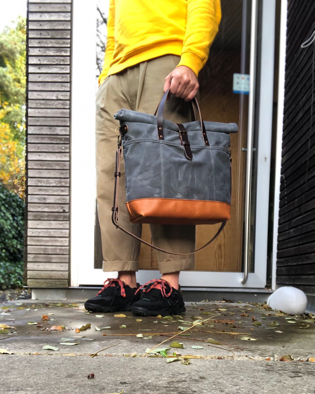 Waxed canvas roll top tote bag with luggage handle attachment