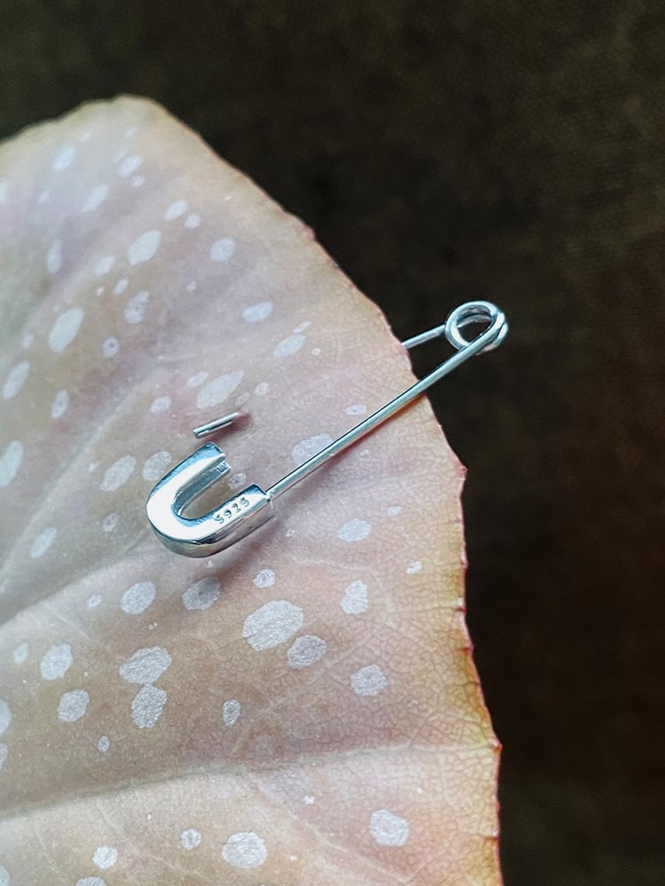 FUN AND QUIRKY

Single safety pin earring in solid 925 sterling silver. This light pieces hook very comfortably through the ears, fastening works the same as a normal safety pin, you pierce it trough your ear, upside down or the other way around. 
Length of this piece is 3cm 
