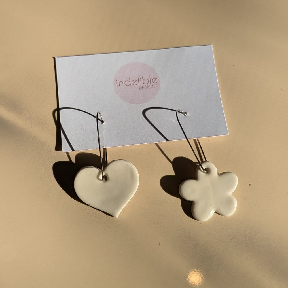 Image of white heart and daisy asymmetrical earrings