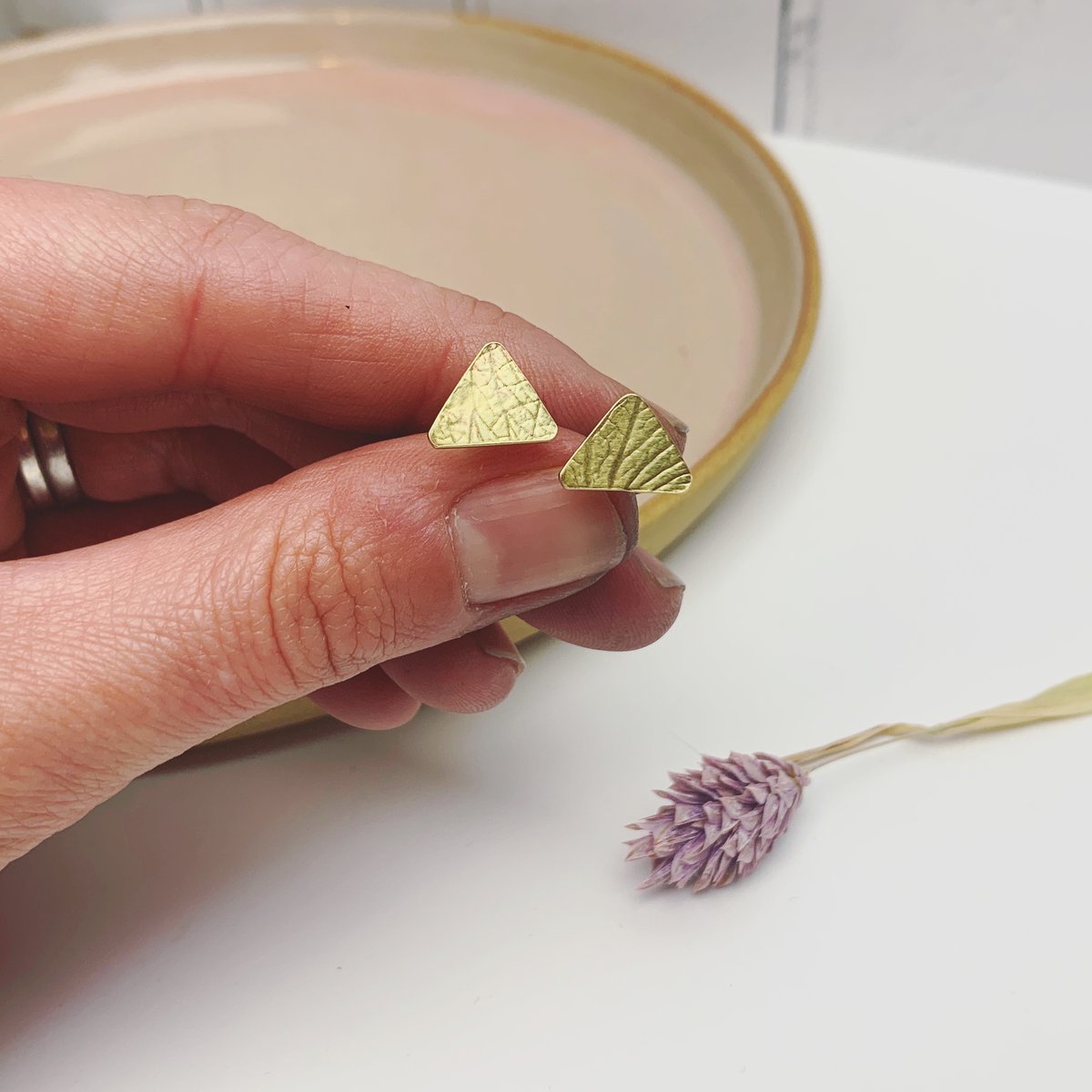 Image of Brass triangle studs with petal imprint.