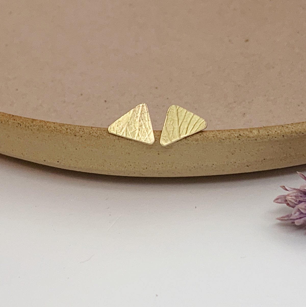 Image of Brass triangle studs with petal imprint.