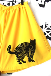 Image of shiny black shorts in yellow 