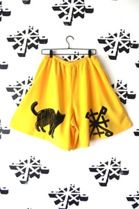 Image of shiny black shorts in yellow 