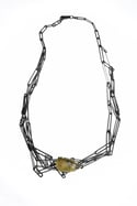 Hand made chain, multiple intertwined chains forming a complex structure set with rutile quartz
