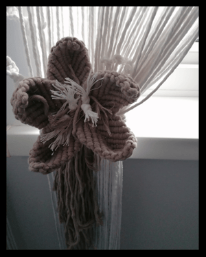 Long macramé curtain with macramé flower tie