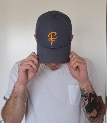Limited Edition Pride Cap designed by Mitchell Boothby. Petrol blue with orange logo on front.