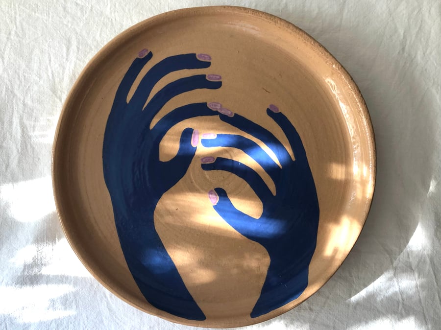 Image of blue hands on :: plate