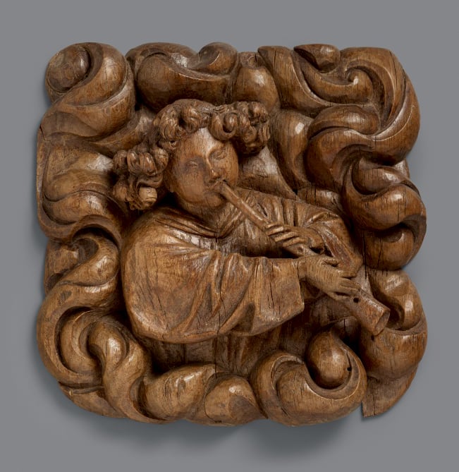 Image of A superbly carved 15th century wood relief of an angel blowing a shawm