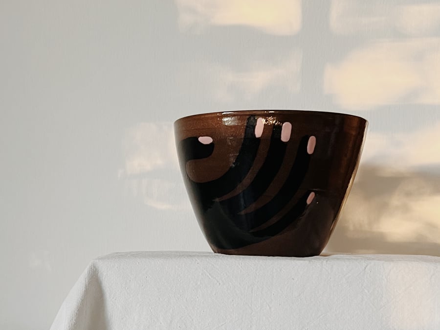 Image of hand on :: dark bowl