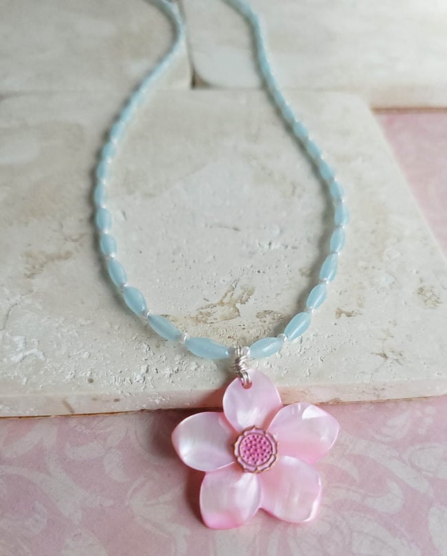 Carved Pink Mother of Pearl Shell Pendant on a Necklace of Small Pale Blue Rice Beads