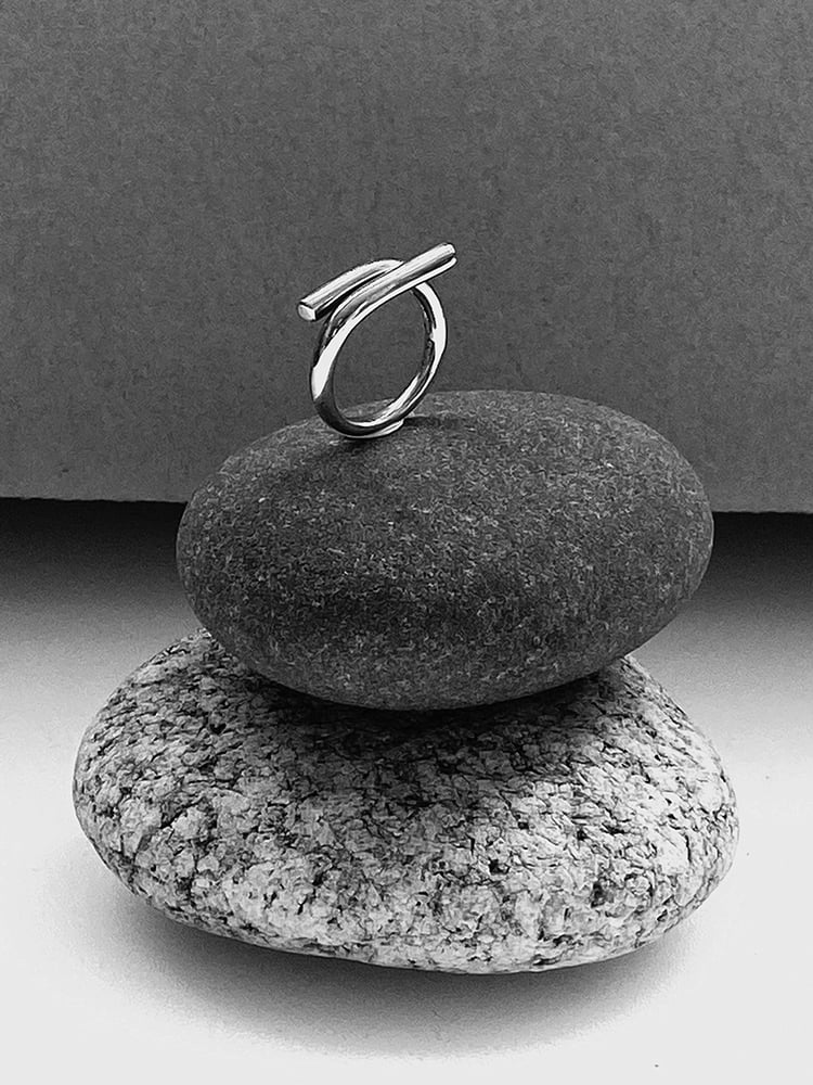 DISTINCTIVE BOLD PIECE WITH TIMELESSNESS IN IT'S LOOK

The adjustable size ring is a one size fits most since you can simply open or close the shape to fit your finger. The approximate fit is between EU sizes 15,5 - 19 and US sizes 5 - 9.

A modern take on fine jewelry is expressed through the clean lines.
This sculptural yet lightweight ring is crafted from sterling 925 silver, and given a polished shine so it will catch and reflect sunlight.

This Unity wire piece is cr...