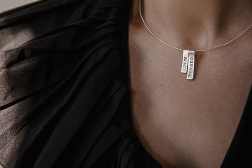 Image of silver pendant with inscription in Latin