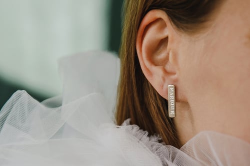 Image of classic silver earrings with inscription in Latin
