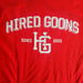 Image of "HIRED GOONS" College shirt.  White on Blood Red