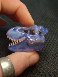 Image 1 of Opalescent cfl reactive Tyrannosaurus rex skull pendant.