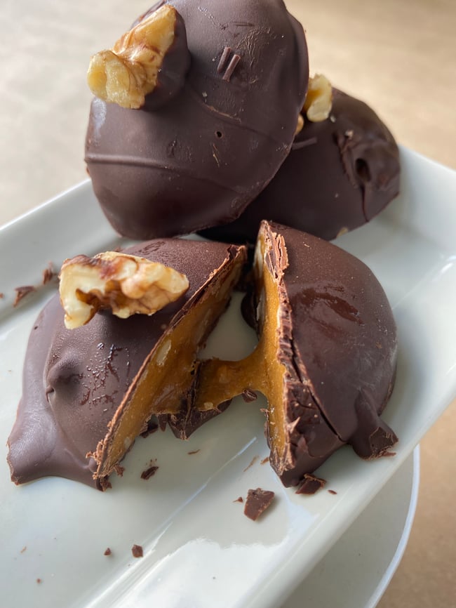 Dark chocolate covered walnut caramel in a tin