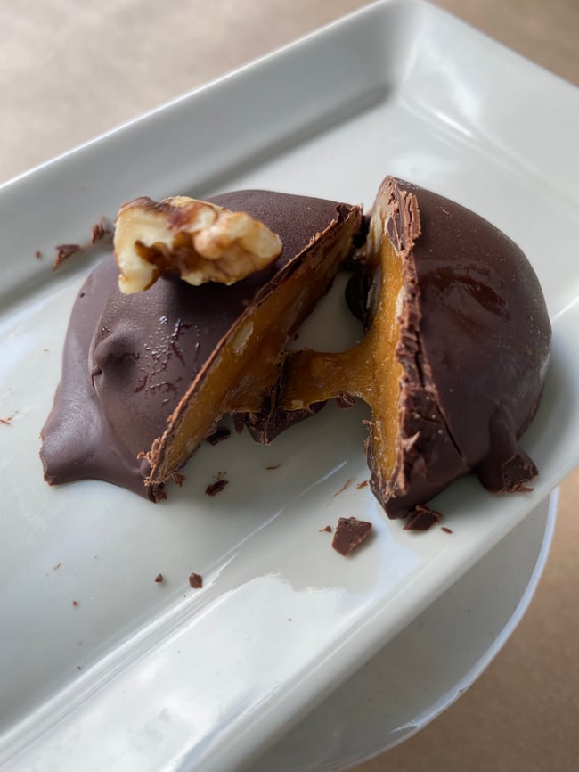 Dark chocolate covered walnut caramel in a tin