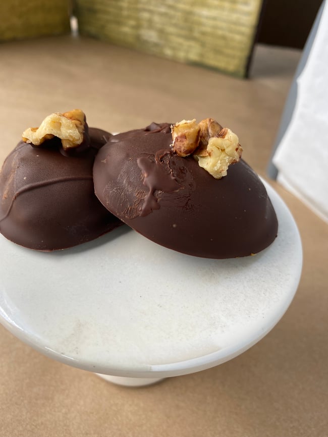 Dark chocolate covered walnut caramel in a tin