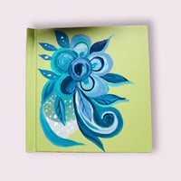 Green sketchbook with blue flower