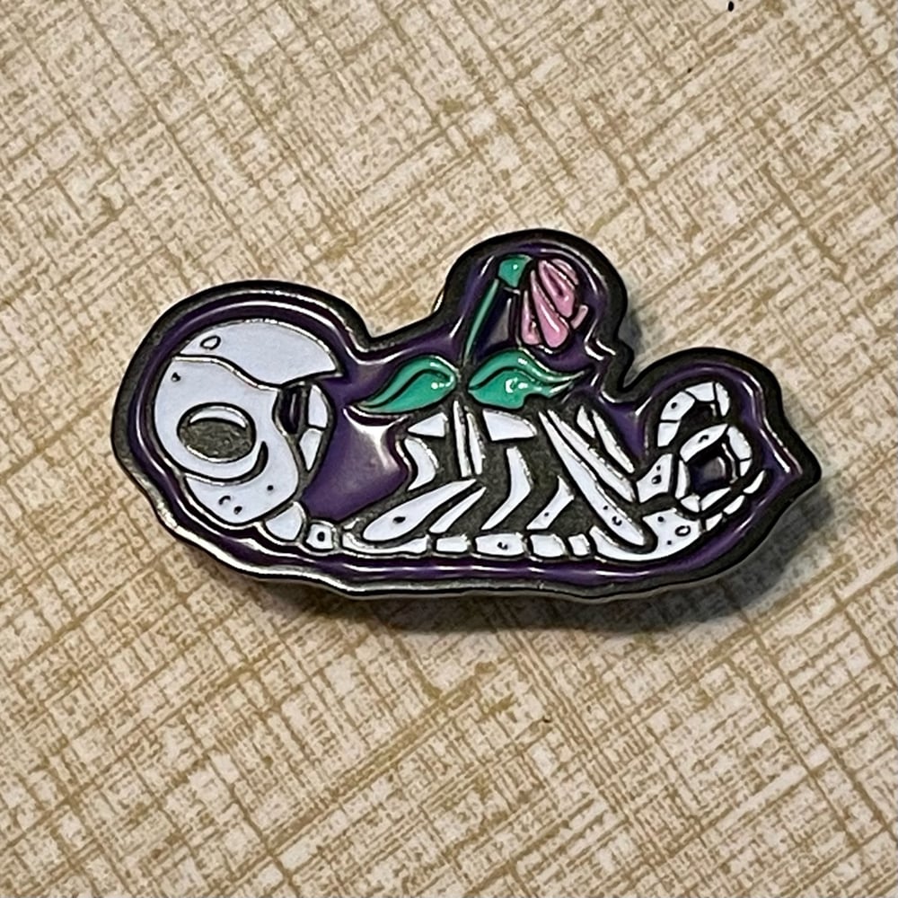 An EX-PARROT Glow-in-the-Dark 1.75" Enamel Pin