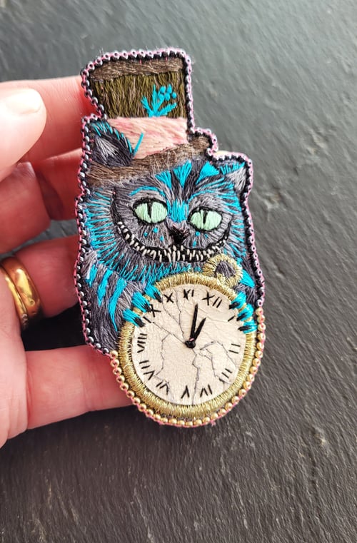 Image of   SUR COMMANDE  Broche Cheshire cat à la montre 