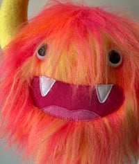 Image 3 of medium pink, orange and yellow horned monster plushie