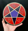 pentacle dark-purple/gold/red on wood disk