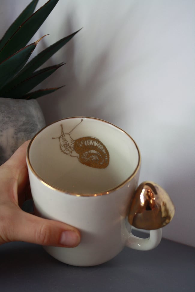 Porcelāna krūze ar sēni un zelta gliemezi