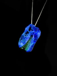 Image 1 of Irrid T-Rex skull pendant with illuminati (UV) teeth.