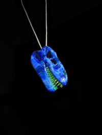 Image 2 of Irrid T-Rex skull pendant with illuminati (UV) teeth.