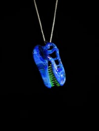 Image 4 of Irrid T-Rex skull pendant with illuminati (UV) teeth.