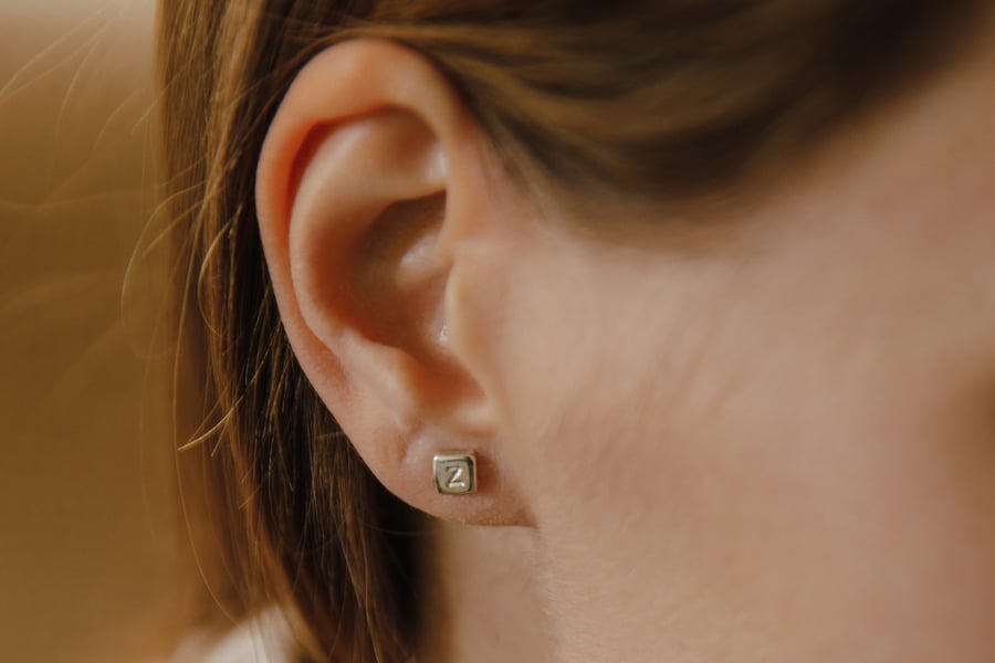 Image of silver earring with letter