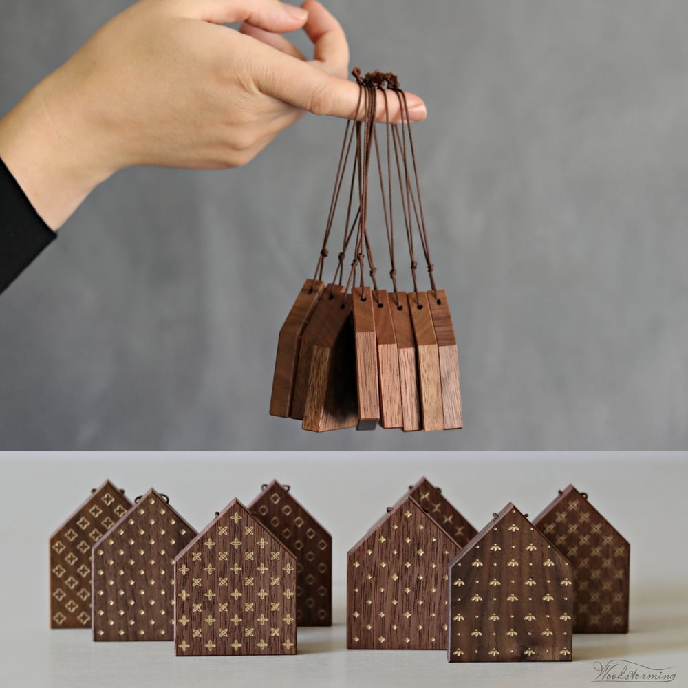 Image of Christmas tree ornaments, elegant wooden houses decorations with gold color patterns, set of 8
