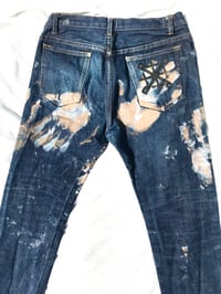 Image of hands on denim jeans 