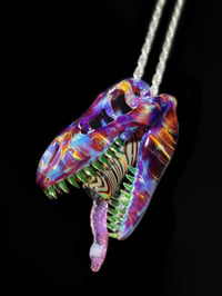 Image 1 of Amber purple T-Rex skull pendant with illuminati teeth, joint tip and L.S D. Tongue 🦖💀💨👅