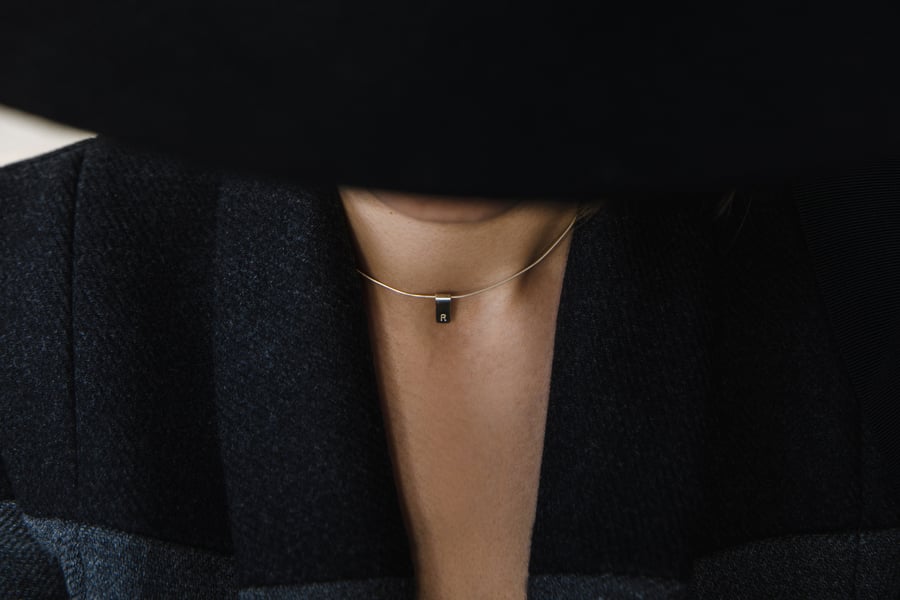 Image of silver pendant with letters