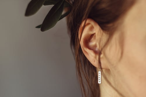 Image of light plain silver earrings with inscription in Latin