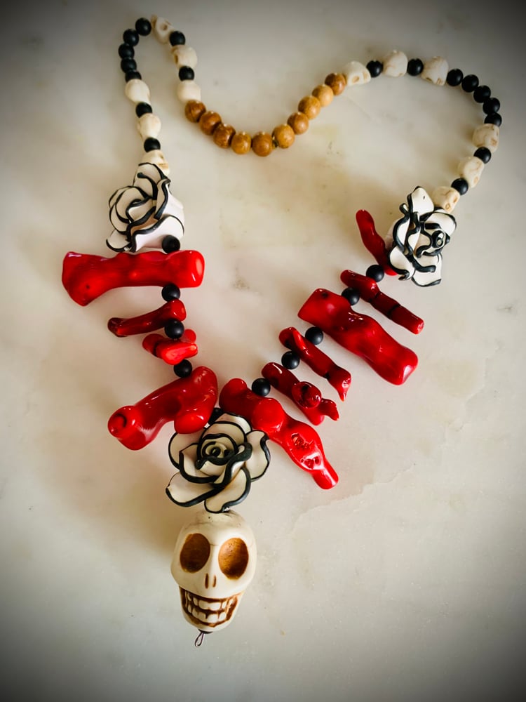 Image of Day of dead raw red coral, onyx and Howlite skulls