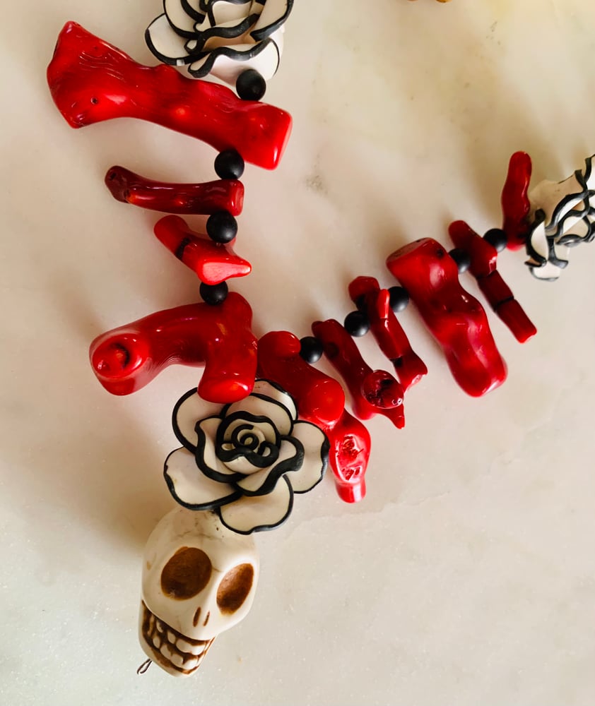 Image of Day of dead raw red coral, onyx and Howlite skulls