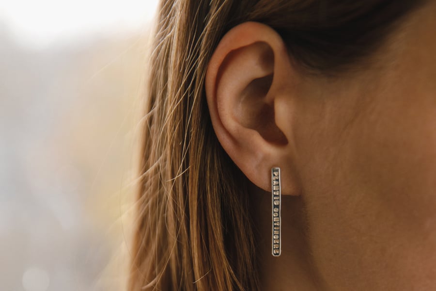 Image of long plain silver earrings with inscription in Latin