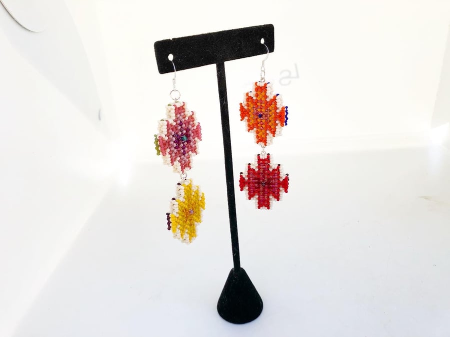 Image of Colorful open rug pattern earrings in opposing colors on each side 