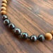 Image of Tahitian pearl necklace with sandalwood beads and a tiger puka shell clasp
