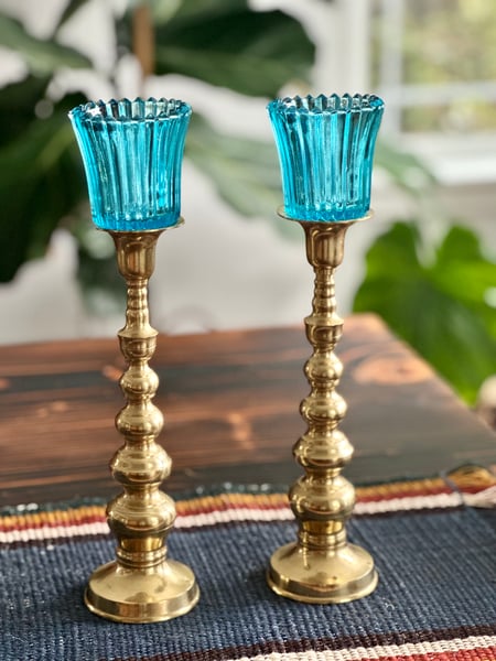 Image of Vintage brass candlestands with blue votives.