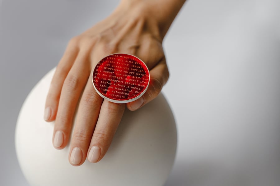 Image of "A fragment from Late Ancient Roman hymn to Sun.." silver ring with red plexiglass